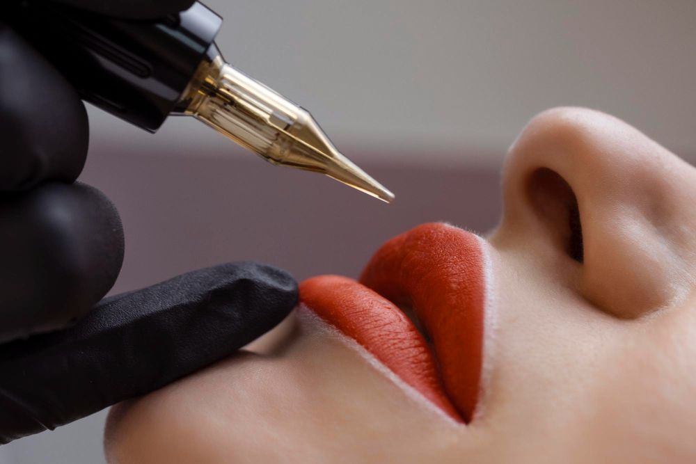 Close-up of a cosmetic tattoo pen applying red lip pigment to a woman's lips.