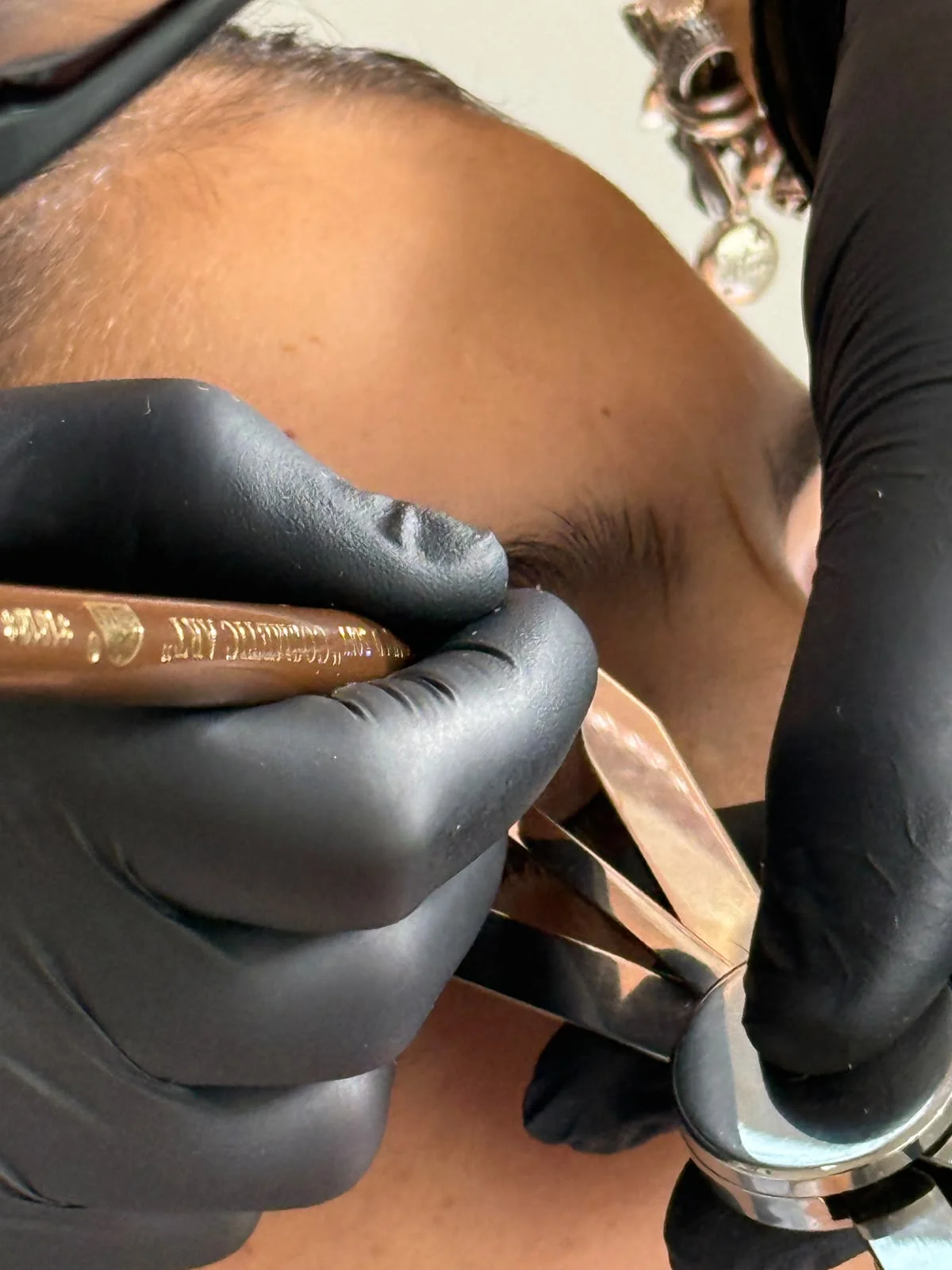 Detalle de precisión con pinza y calibrador durante el diseño de cejas en formación presencial con Cristina Badea